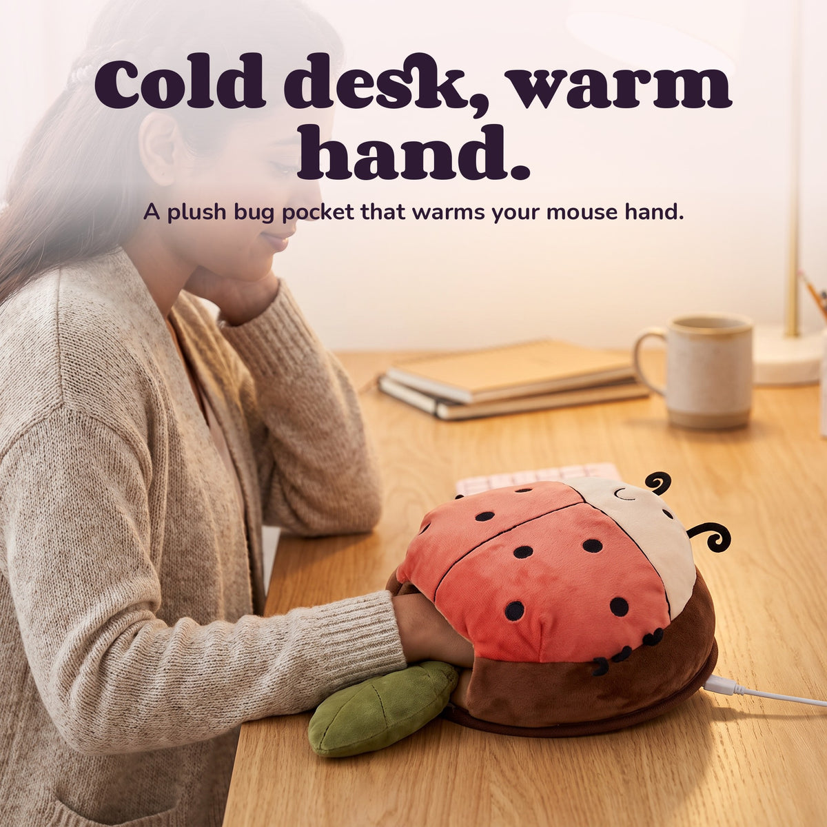 Woman using the Snugglet Bug Muff – Cold desk, warm hand.