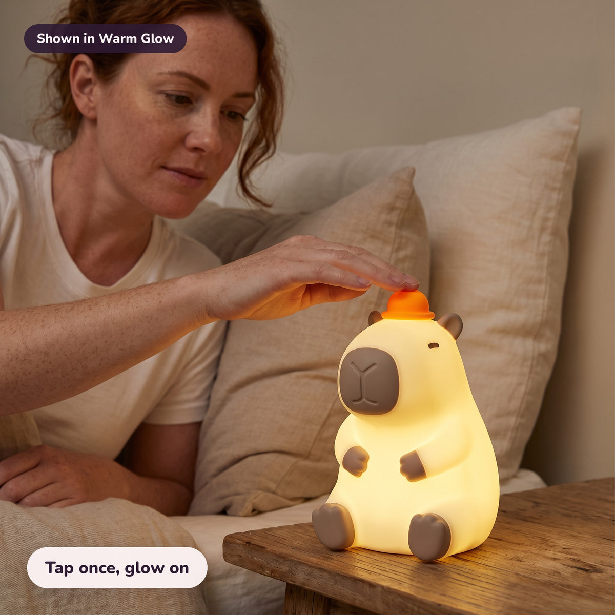 Woman using the Snugglet Capy Glow in Warm Glow – Tap once, glow on
