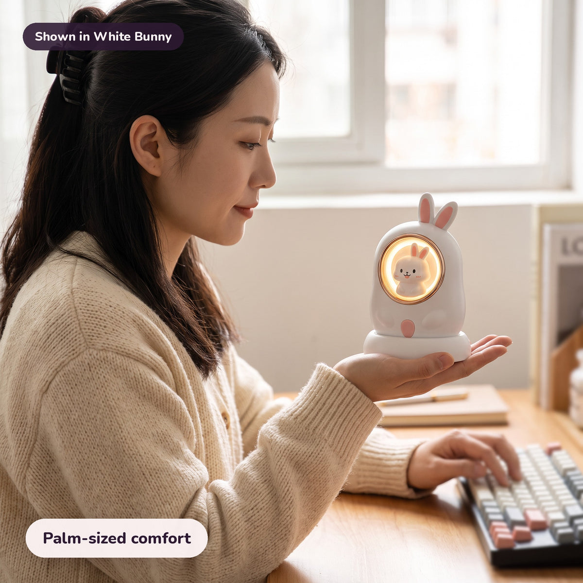 Woman using the Snugglet Bun Warmer in White Bunny – Palm-sized comfort