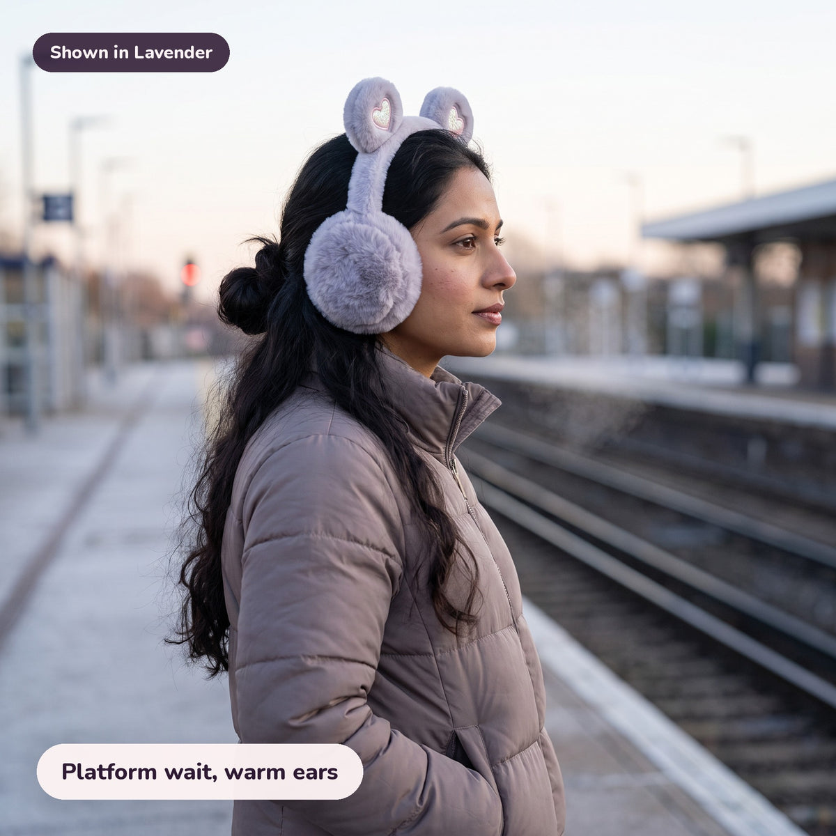 Woman using the Snugglet Bear Muffs in Lavender – Platform wait, warm ears